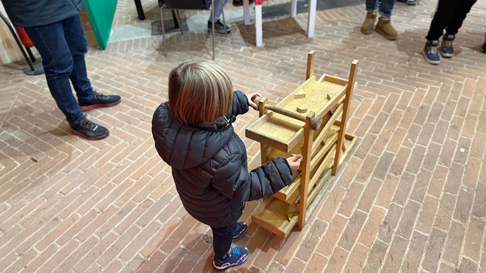 Un bambino alle prese con un gioco di legno