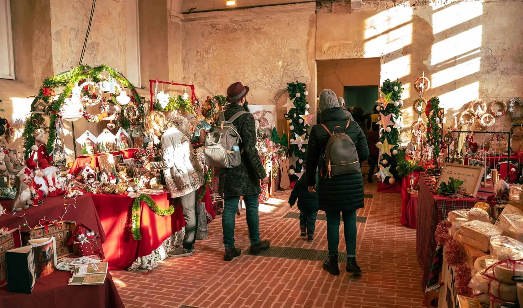 Due visitatori passeggiano tra le bancarelle del Mercatino di Natale è Reale