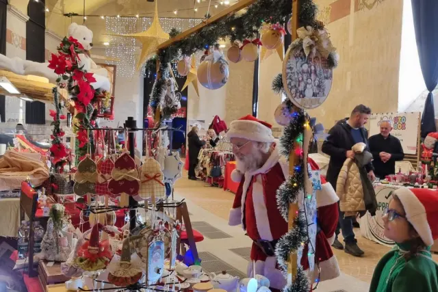 Babbo Natale e un elfo tra le bancarelle del mercatino