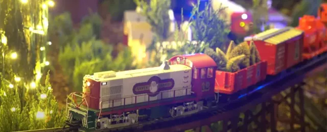 Un locomotore in miniatura tra le luci del plastico